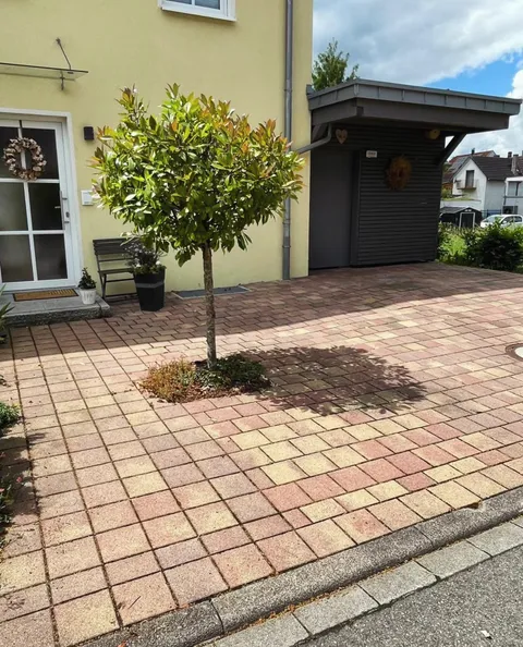 Vorgartengestaltung mit Pflasterung und Carport